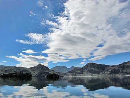 Las nubes reflejan en el espejo que es el agua de la bahia